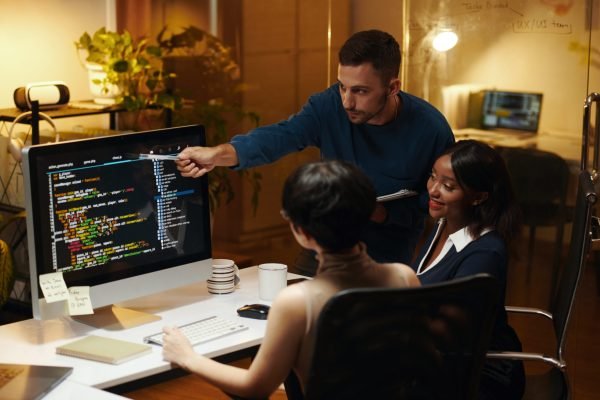 Developer explaining details in programming code his colleagues from front end team