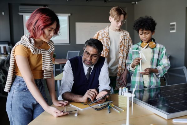 Group of ethnically diverse students learning about renewable energy technologies during lesson at school